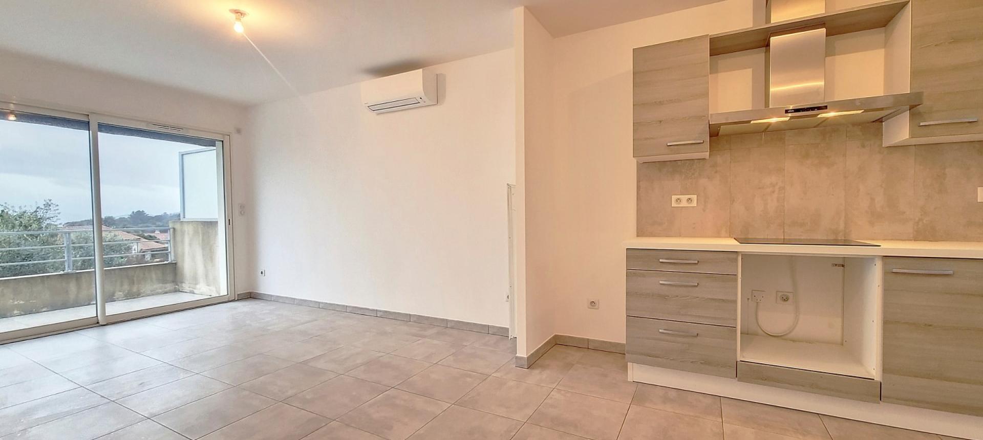 F2 à louer l'Oliveraie Afa entrée séjour cuisine